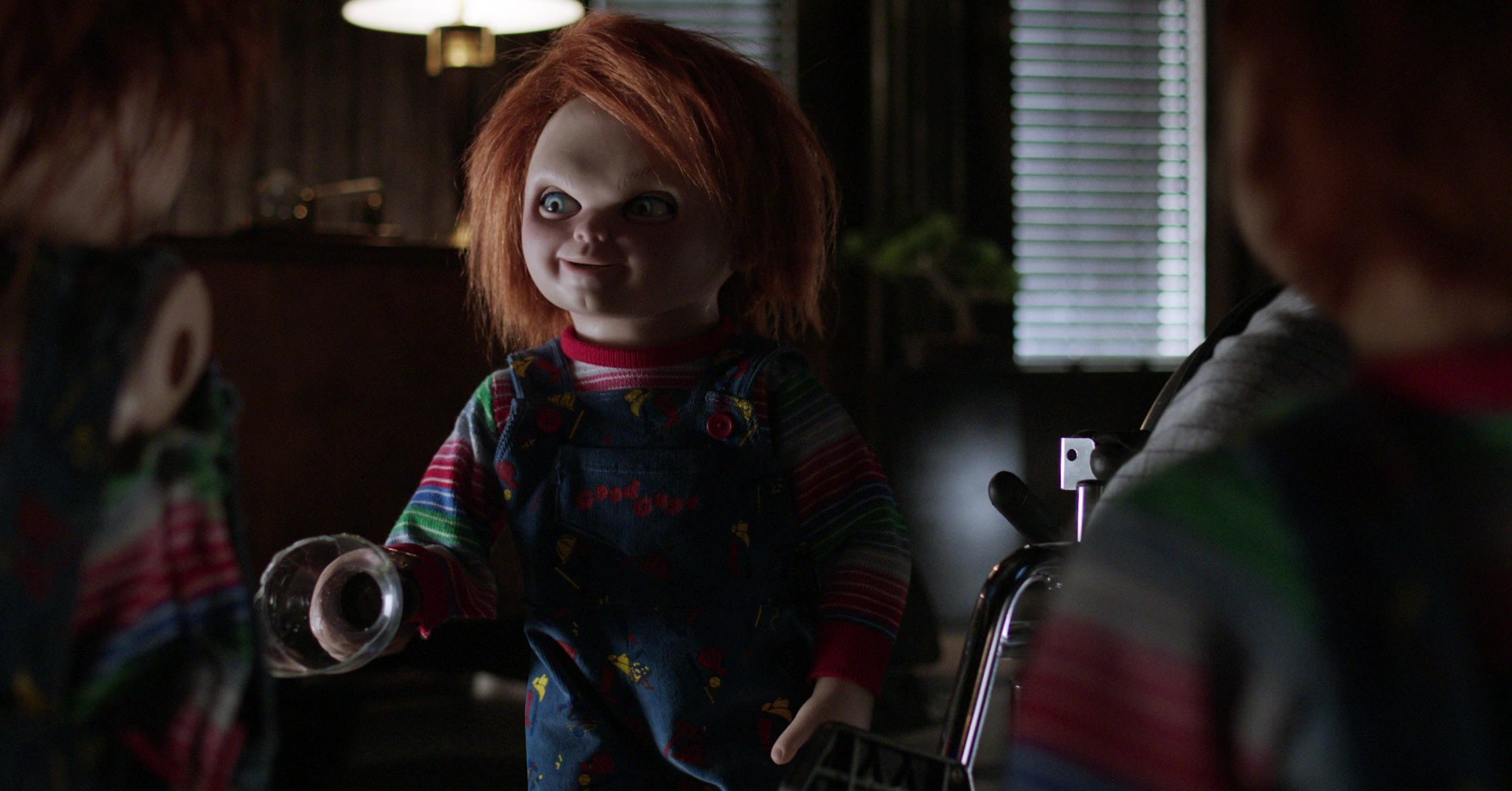 Chucky conversando com duas outras bonecas chucky no culto de chucky