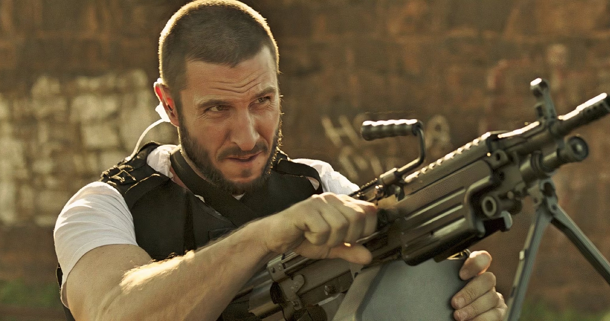 Ray (Pablo Schreiber) bombeando a recarga em um rifle de assalto em Den of Thieves