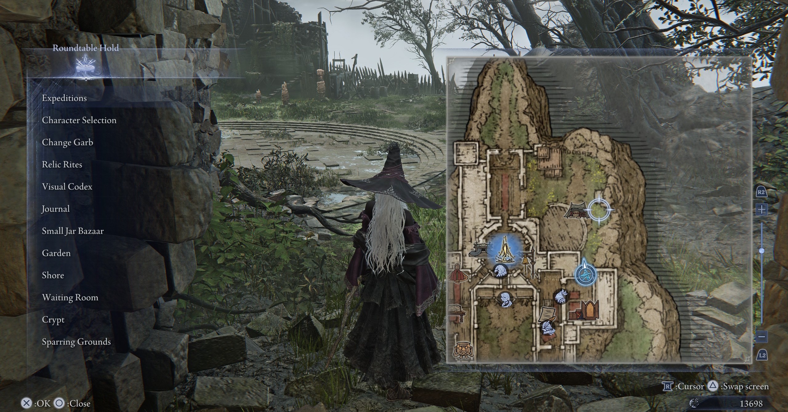 O recluso em Elden Ring Nightreign, em pé no campo de treinamento da Rountable Hold, onde a presença à espreita está O recluso em Elden Ring Nightreign, em pé no campo de treinamento da Rountable Hold, onde a presença à espreita está