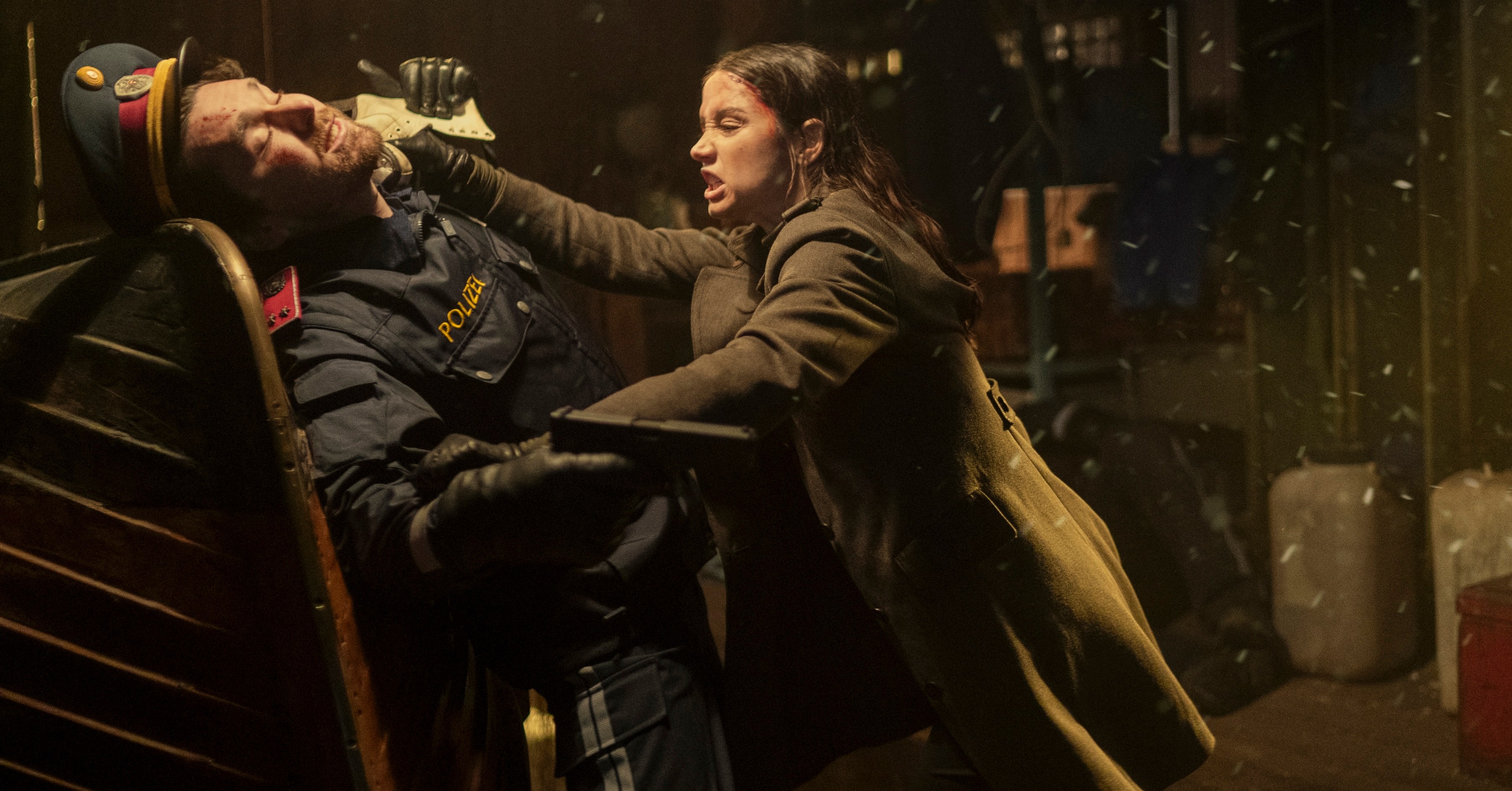 Eve (Ana de Armas) estrangula um homem que empunhava armas em um chapéu militar retro e um coato de trincheira no spin-off de John Wick-off Eve (Ana de Armas) estrangula um homem que empunhava armas em um chapéu militar retro e um coato de trincheira no spin-off de John Wick-off