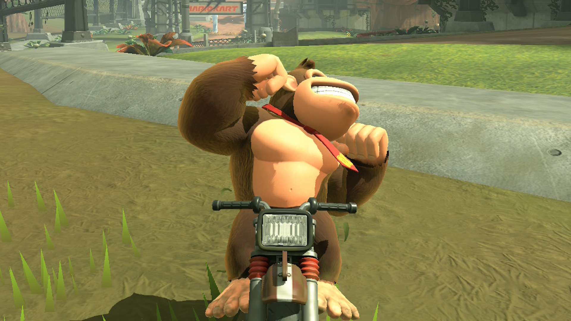 Donkey Kong flexionando seu bíceps enquanto andava de bicicleta minúscula em Mario Kart World
