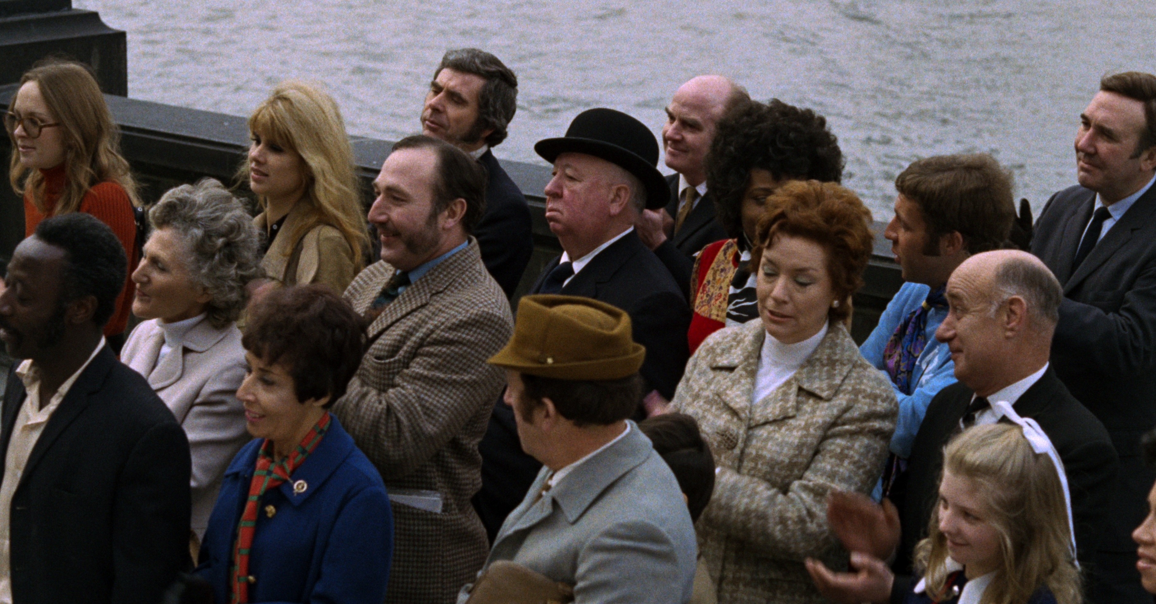 Uma multidão de pessoas fica em um cais em frenesi