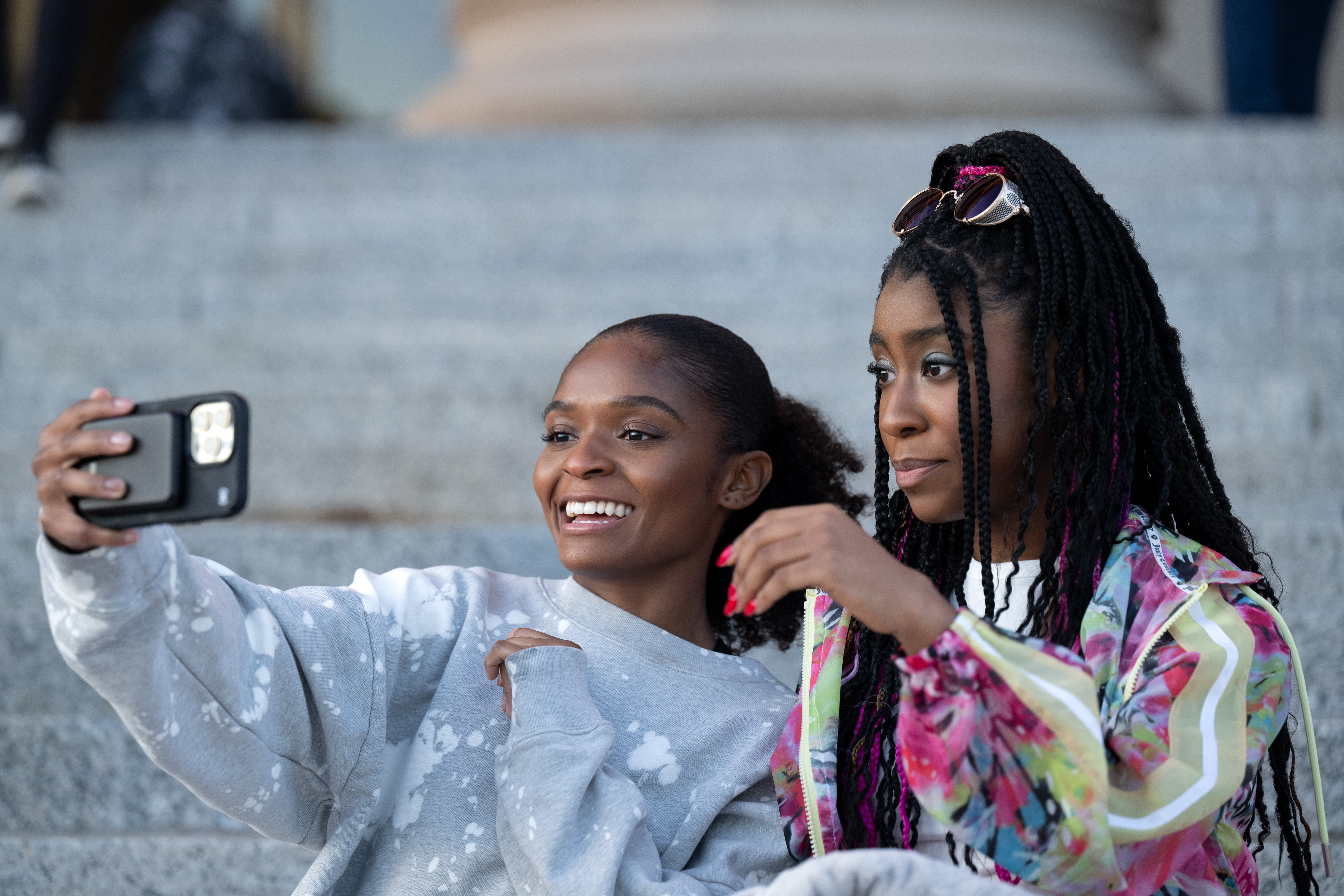 Natalie e Riri sentados nos degraus, tirando uma selfie em Ironheart