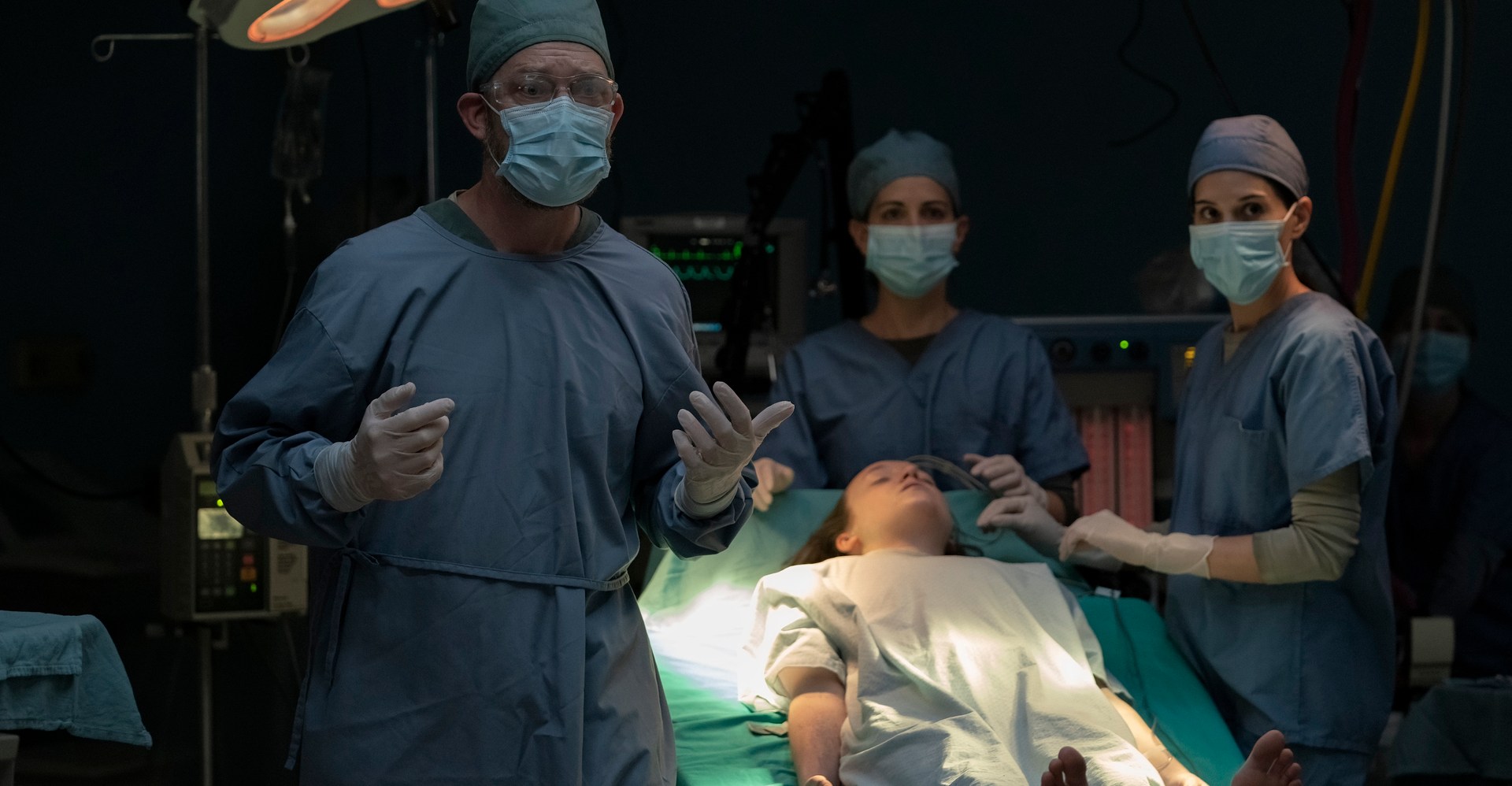 Homens e mulheres em matagais e máscaras ficam em torno de uma mesa cirúrgica segurando a inconsciente Ellie (Bella Ramsey), prestes a sacrificar -a, na última temporada da temporada 1, episódio 9 Homens e mulheres em matagais e máscaras ficam em torno de uma mesa cirúrgica segurando a inconsciente Ellie (Bella Ramsey), prestes a sacrificar -a, na última temporada da temporada 1, episódio 9