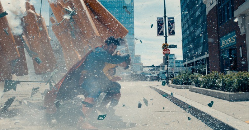 Em um imóvel do cinema de 2025, Superman salva uma criança pequena da morte durante uma explosão nas ruas de Metropolis.  Em um imóvel do cinema de 2025, Superman salva uma criança pequena da morte durante uma explosão nas ruas de Metropolis.