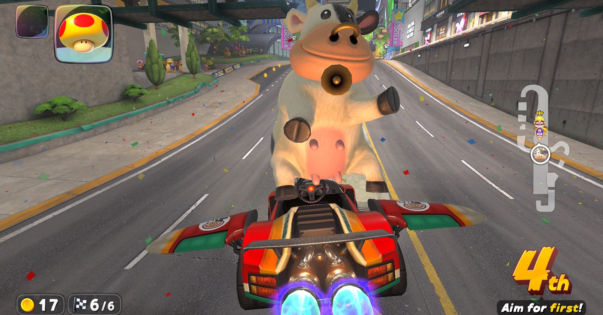 A vaca em Mario Kart World, posando nas patas traseiras enquanto se levanta em um carro que está voando como um avião