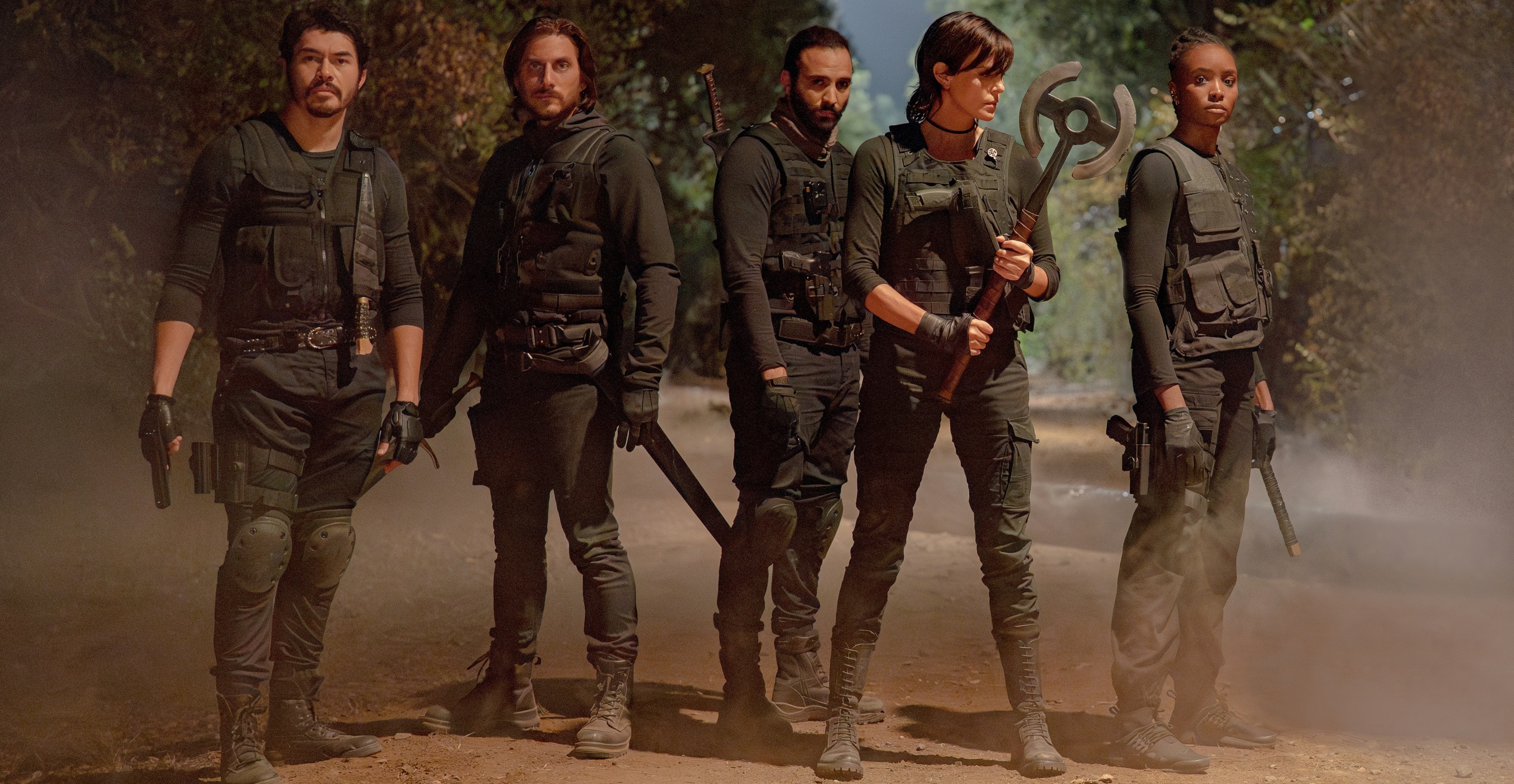Uma equipe de imortais armados e seus parceiros (interpretados por Henry Golding, Luca Marinelli, Marwan Kenzari, Charlize Theron e Kiki Layne) usando roupas de estilo militar escuro em uma estrada empoeirada no velho guarda 2 Uma equipe de imortais armados e seus parceiros (interpretados por Henry Golding, Luca Marinelli, Marwan Kenzari, Charlize Theron e Kiki Layne) usando roupas de estilo militar escuro em uma estrada empoeirada no velho guarda 2