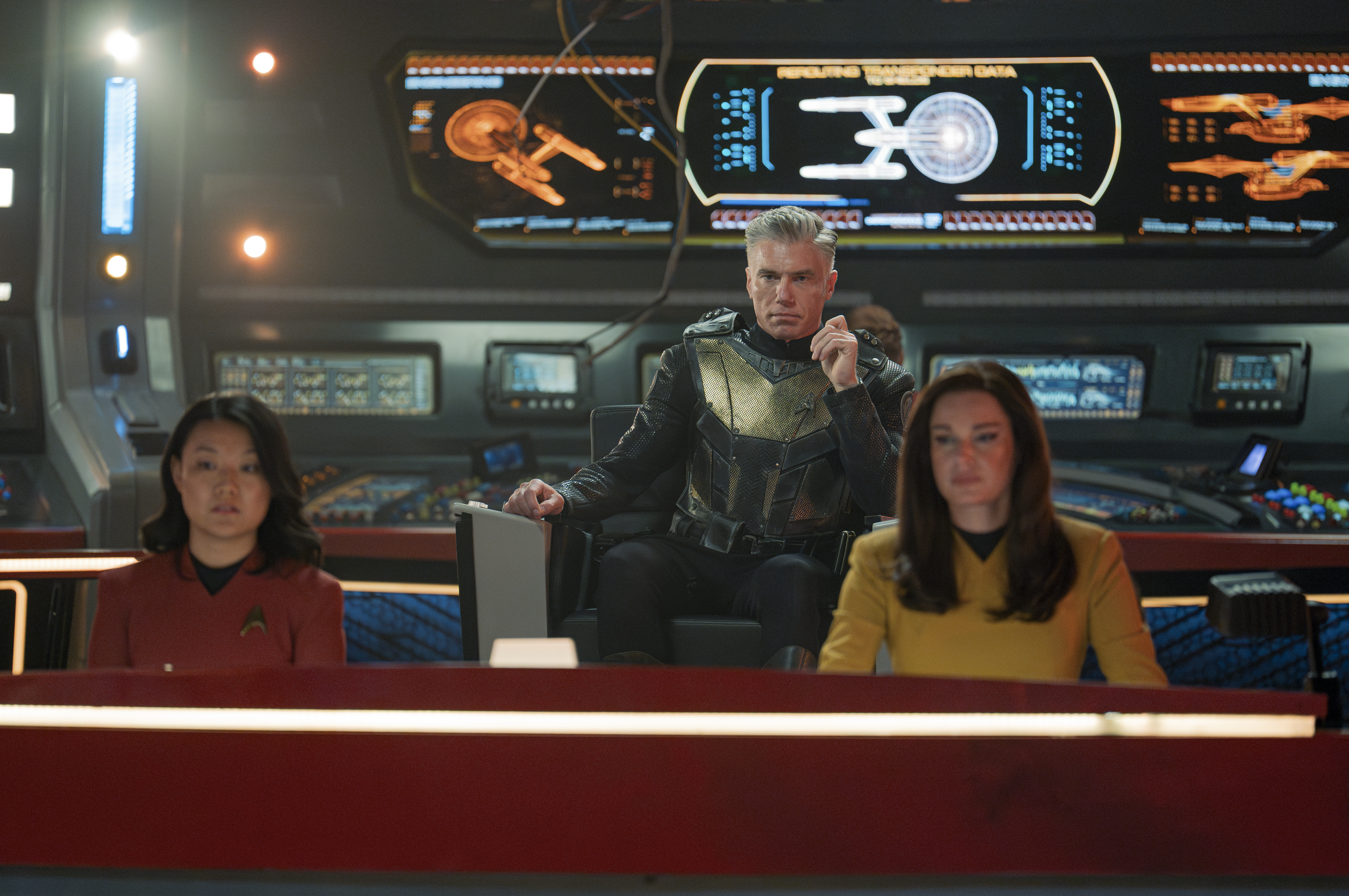 Rong Fu como Mitchell, Anson Mount como Pike e Rebecca Romijn como Una sentados na ponte do USS Enterprise em Star Trek: Strange New Worlds