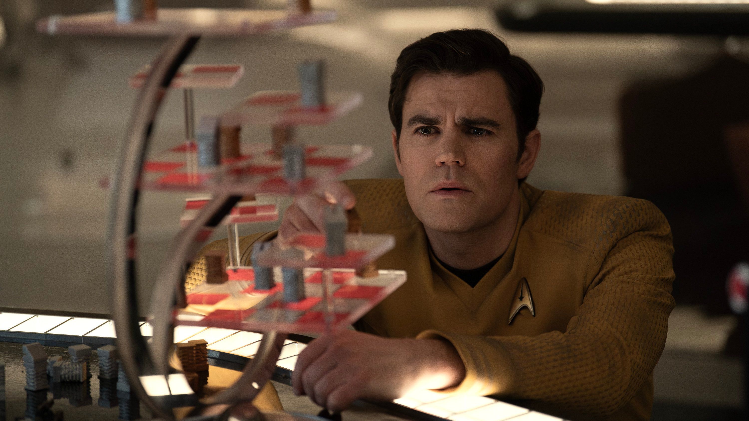 Paul Wesley enquanto Kirk olha para um quadro de jogos em vários níveis em Star Trek: Strange New Worlds