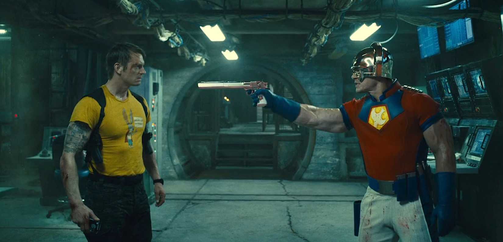 Paacemaker (John Cena) aponta uma arma absurdamente longa na bandeira de Rick (Joel Kinnaman) no esquadrão suicida