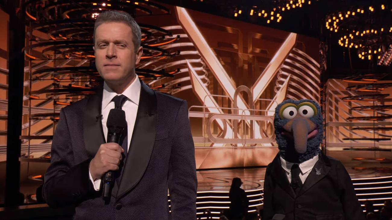 O apresentador do Game Awards, Geoff Keighley, fica ao lado de Gonzo, dos Muppets, ambos usando ternos semelhantes.