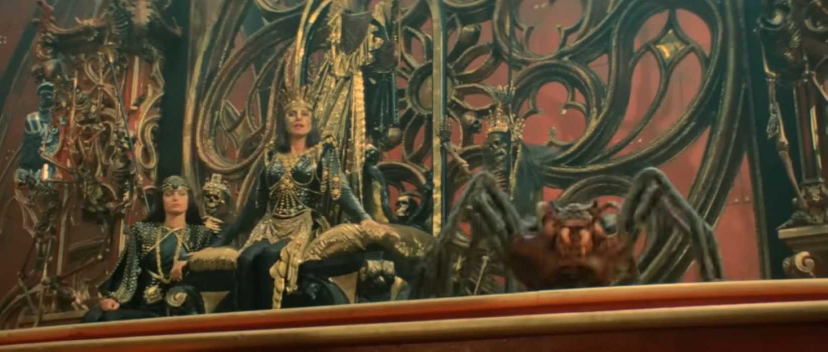 A rainha Gedren senta -se em um cenário ornamentado com sua gigantesca aranha de estimação em uma cena do filme Red Sonja de 1985.