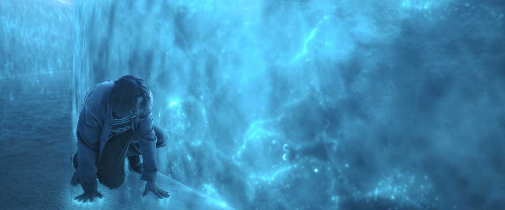 Um homem agacha -se em uma sala construída a partir de tecnologia alienígena. As paredes e o piso são azuis e iluminados por dentro como se por raios.