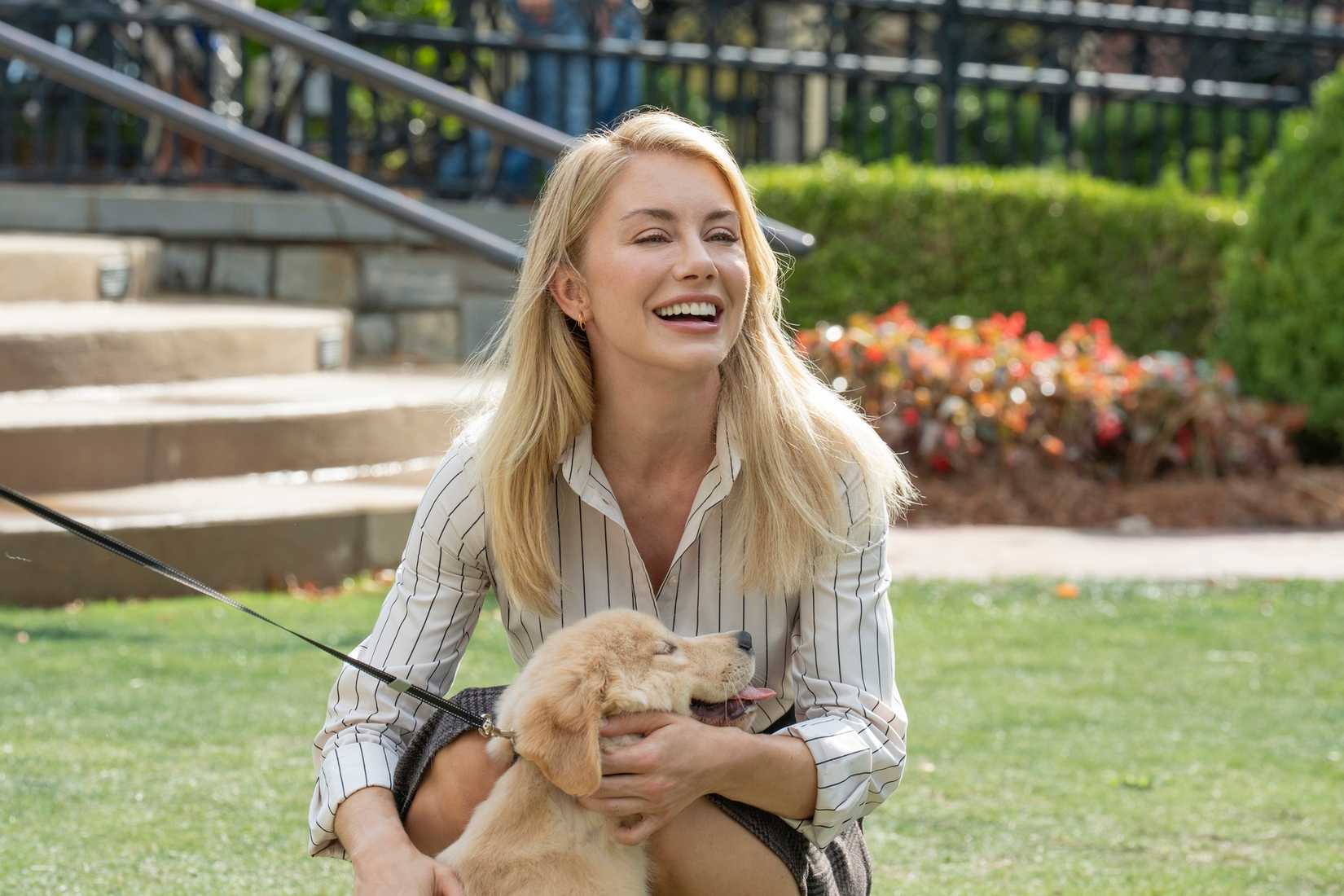 Emilia Harcourt (Jennifer Holland) segura um filhote em pacotes