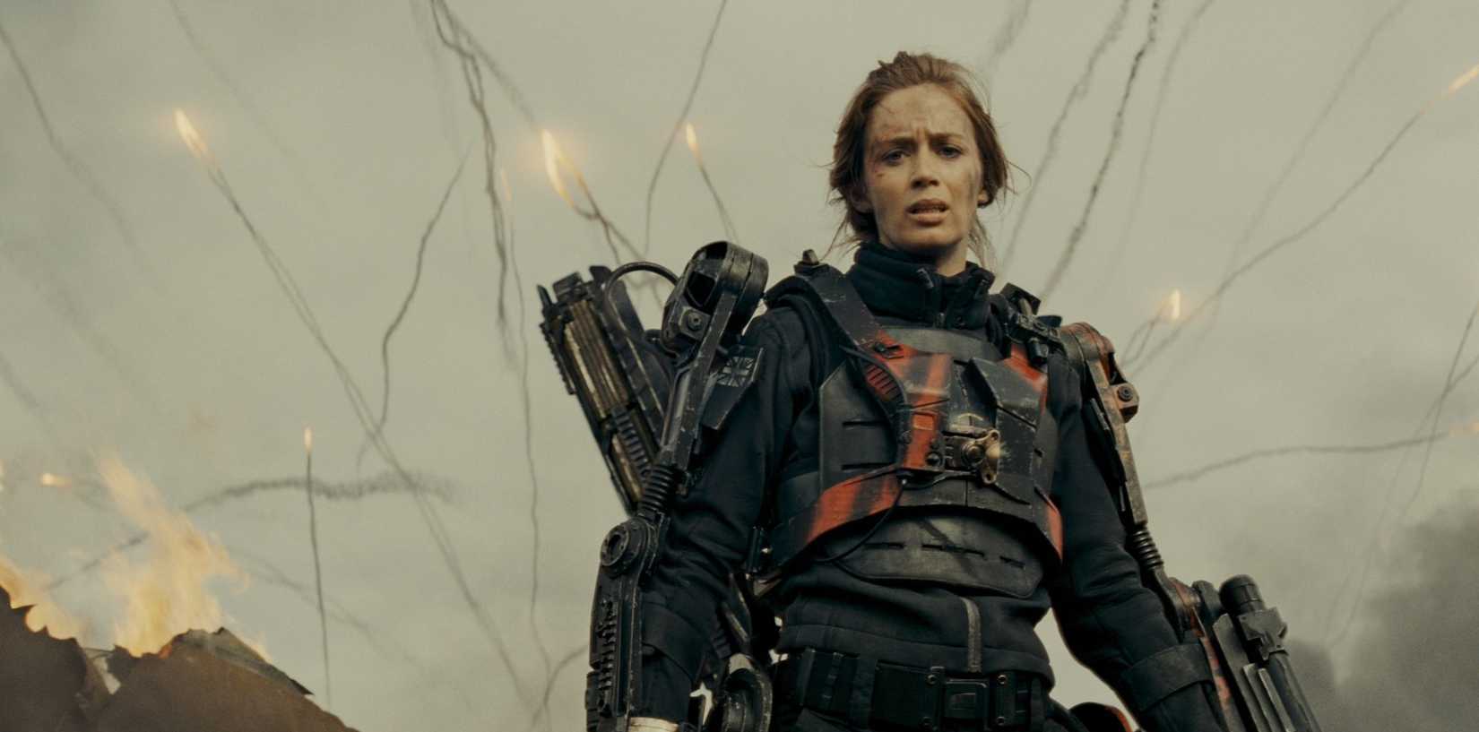 Emily Blunt em sua armadura de guerra quando mísseis explodirem atrás dela na ponta de amanhã