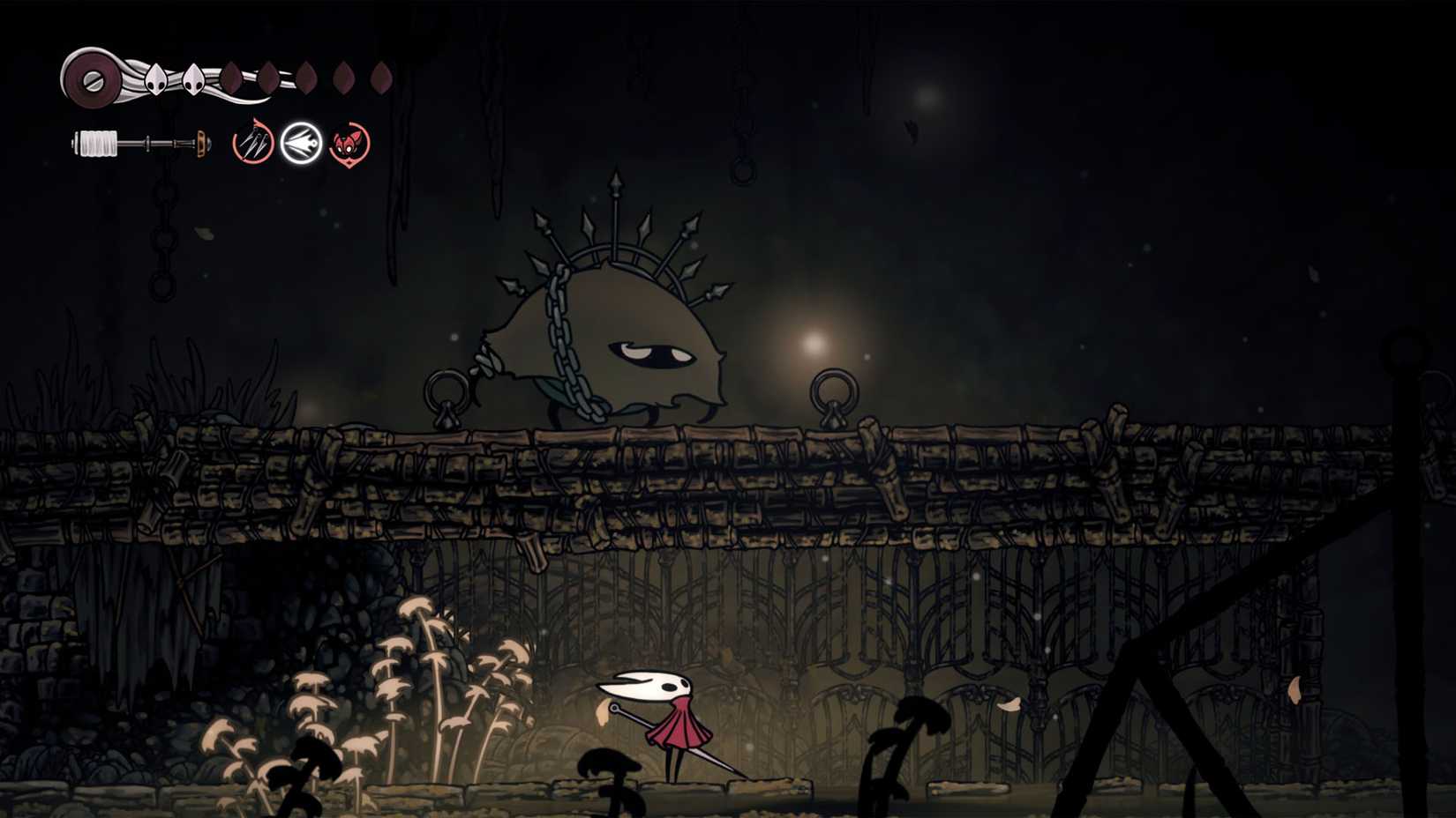 Hornet escondido de um barracão em Hollow Knight: Silksong.