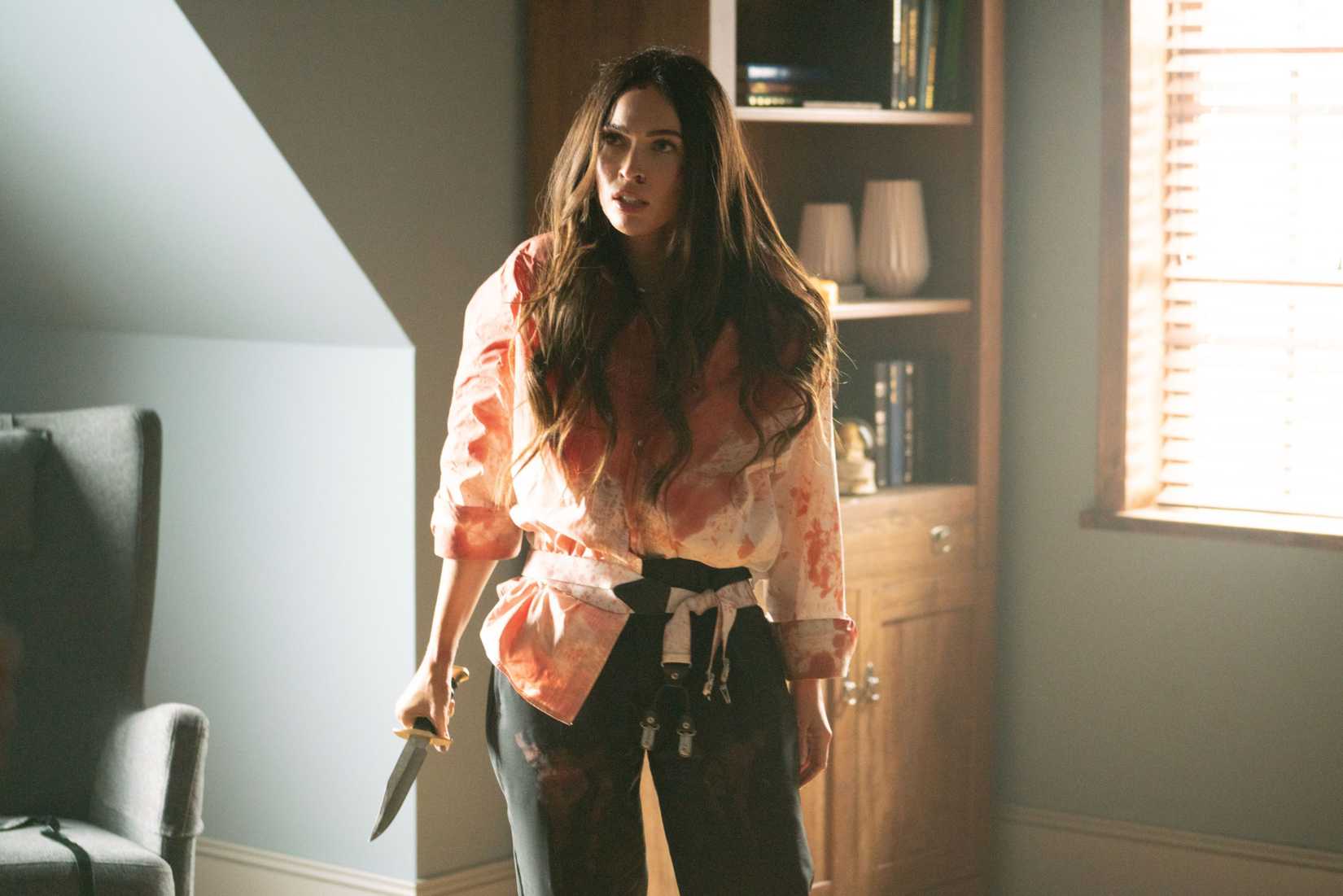 Megan Fox como Emma, coberta de sangue e brandindo uma faca até a morte