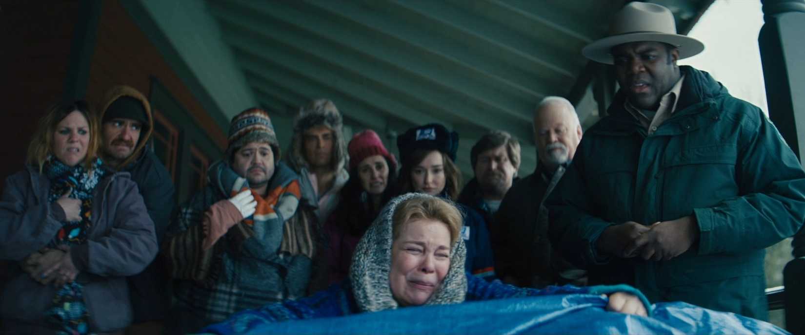 Um conjunto de habitantes da cidade olha um cadáver em uma cena do filme lobisomens dentro