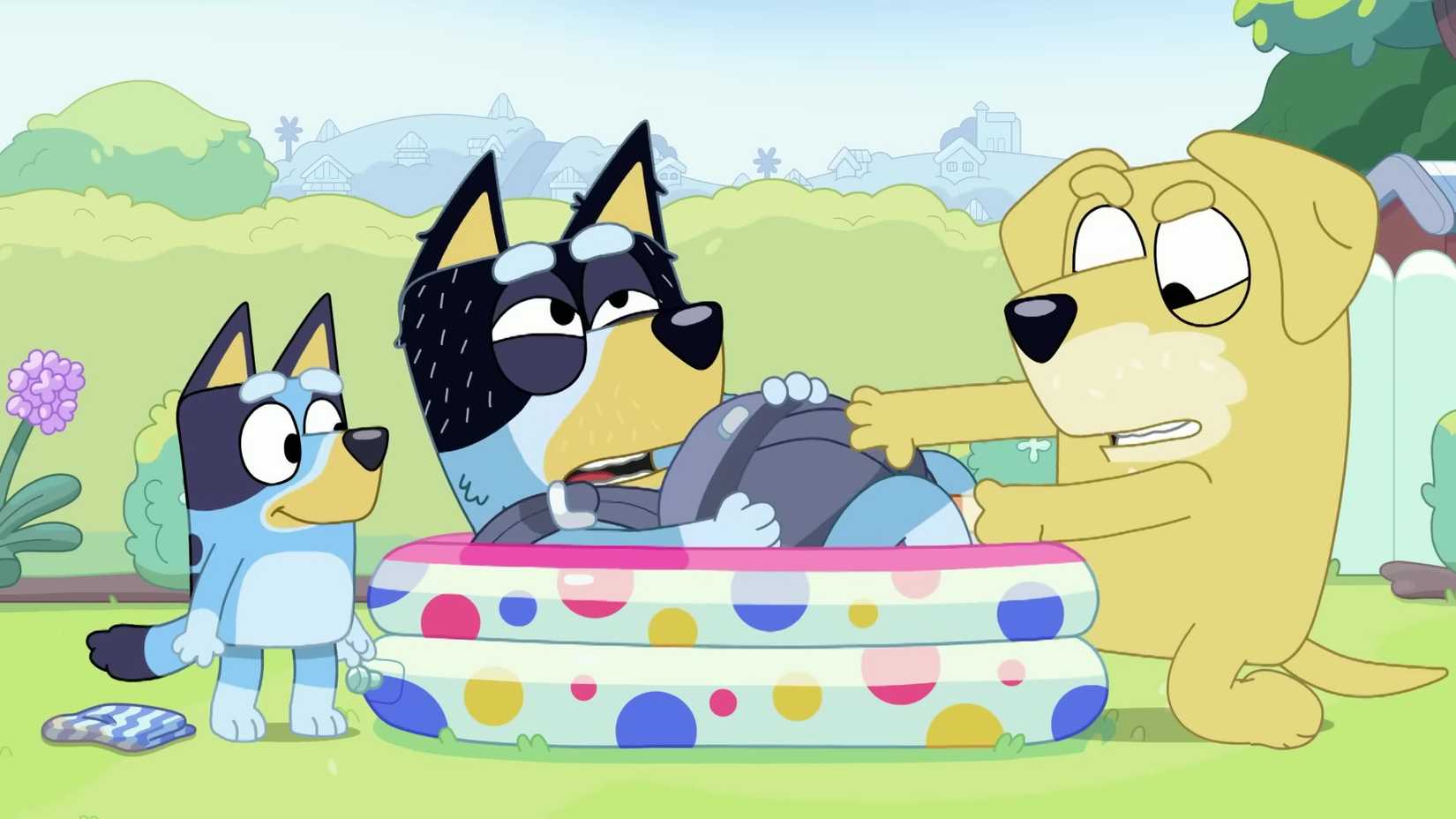 Um ainda de Bluey. Papai deita -se em uma piscina no jardim, usando um transportador de bebê, com um olhar doloroso no rosto. O pai de Lucky está puxando duro com a mão entre as pernas do pai. O Bluey olha feliz.
