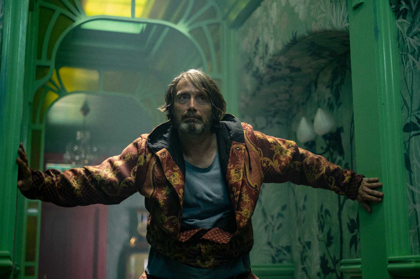 Uma imagem do coelho de poeira das atrações na estrada. Apresenta Mads Mikkelsen como um assassino sem nome. Ele parece angustiado.