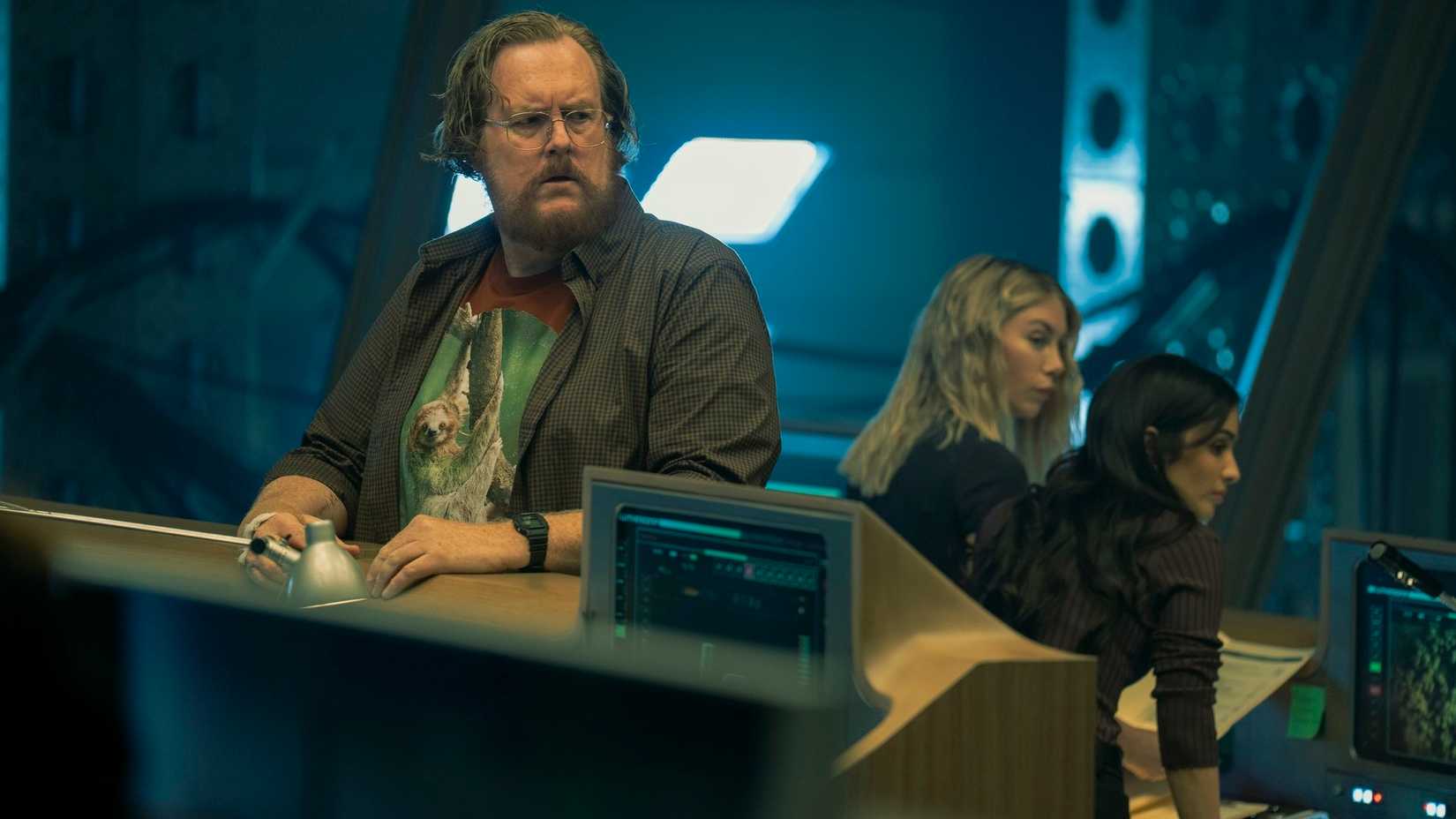 John Economos (Steve Agee) tenta distrair os aliados de Lex Luthor enquanto Emilia Harcourt (Jennifer Holland) e Sasha Bordeaux (Sol Rodriguez) procuram a localização de Peacemaker na 2ª temporada de Peacemaker 