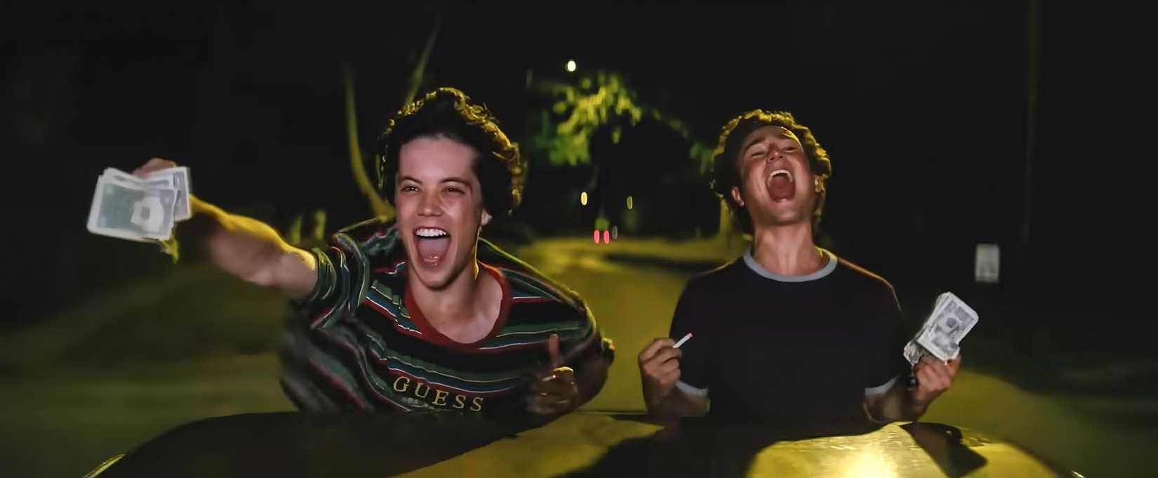 Os meninos do Snack Shack gritando com dinheiro nas mãos enquanto andam de carro