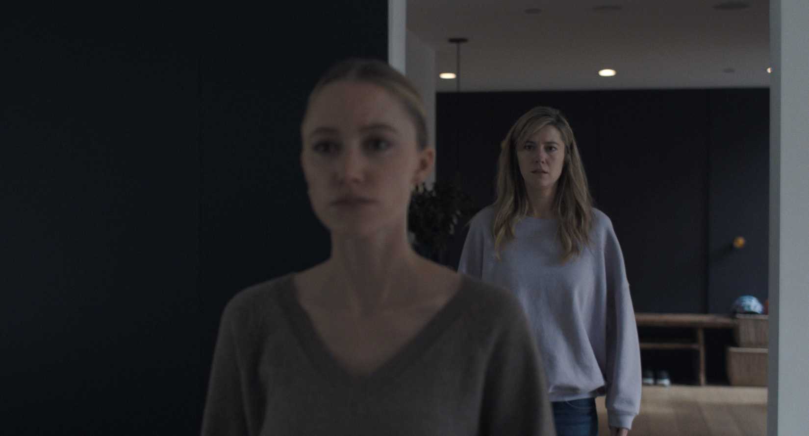 Em uma cena do remake de 2025 de A mão que balança o berço, Maika Monroe, como uma babá instável, fica em primeiro plano (mas fora de foco), enquanto Mary Elizabeth Winstead, como sua chefe, observa ao fundo (mas em foco).