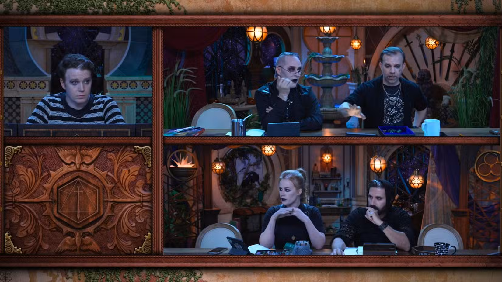 Captura de tela do episódio 4 da Critical Role Campaign 4. Apresenta Brennan Lee Mulligan, Marisha Ray, Luis Carazo e Liam O'Brien. Eles estão sentados à mesa, todos vestindo trajes góticos. 
