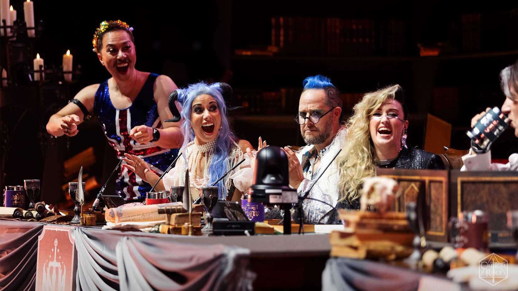 Da esquerda para a direita, Sam Riegel, Laura Bailey, Taliesin Jaffe e Ashley Johnson no palco em Londres em outubro de 2023. Durante o show na Wembly Arena, eles usaram trajes elaborados, incluindo o macacão Union Jack de Riegel.