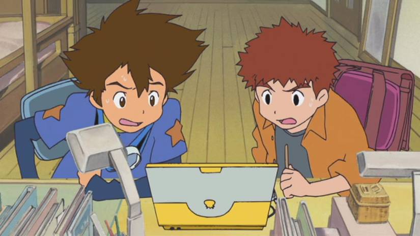 Tai e Izzy, dois meninos, olhando com expressões preocupadas em suas telas de laptop de Digimon: o filme