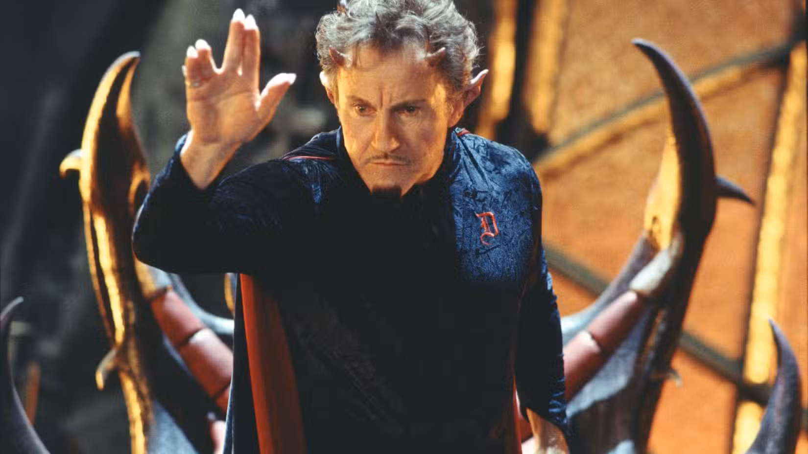 Harvel Keitel como o diabo segurando a mão em Little Nicky