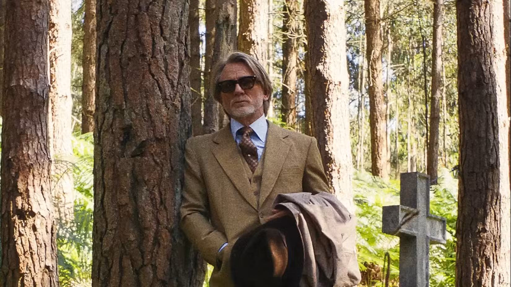 Benoit Blanc, interpretado por Daniel Craig, espreita na floresta ao redor da igreja em uma cena de Wake Up Dead Man: A Knives Out Mystery.