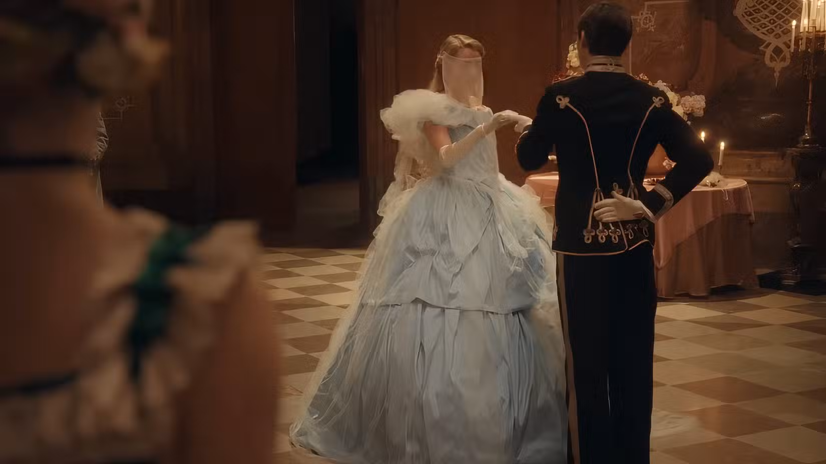 Um príncipe dança com uma mulher em um vestido de baile azul fofo e véu em The Ugly Stepsister