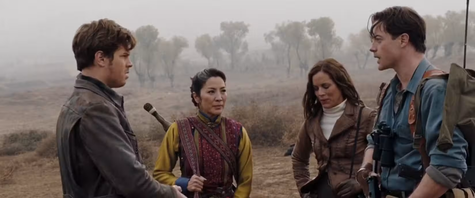 A antiga feiticeira Zi Yuan (Michelle Yeoh) está em um campo enevoado com o casal de aventureiros Evelyn (Maria Bello) e Rick (Brendan Fraser) em A Múmia: Tumba do Imperador Dragão, o único filme que os protagonistas do Oscar 2023 de Melhor Ator e Atriz Fraser e Yeoh fizeram juntos