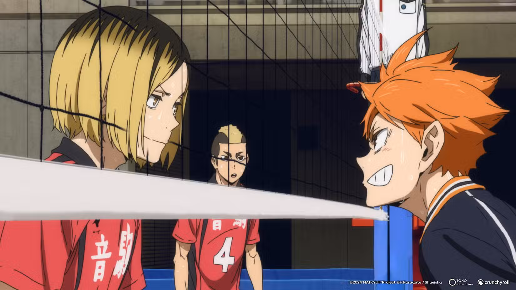 Um garoto loiro de uniforme vermelho e um garoto de cabelo laranja de uniforme preto se enfrentam em uma rede de vôlei em Haikyu!! A batalha do lixo