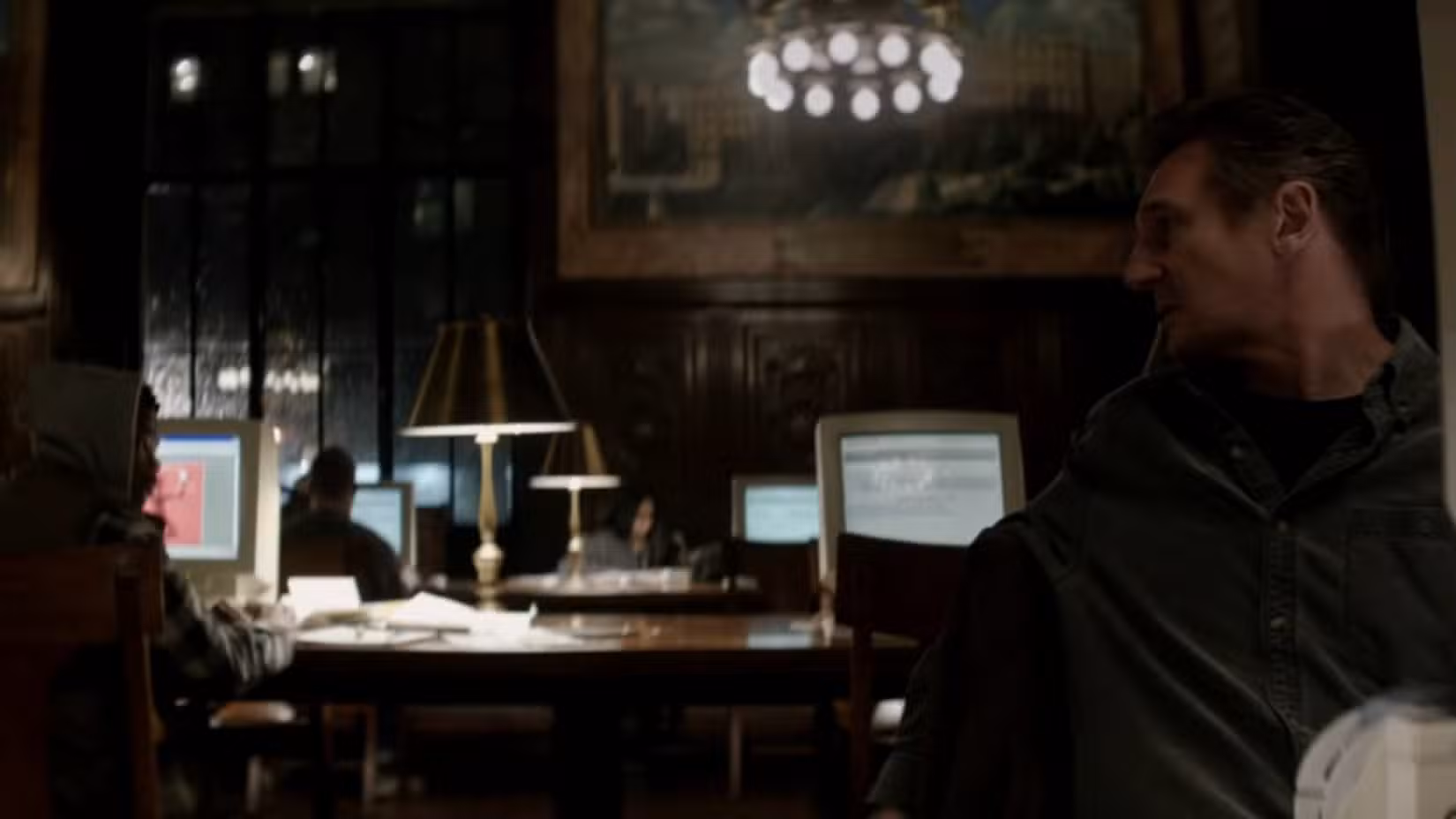 Liam Neeson faz pesquisa em uma biblioteca pública em cena do filme A Walk Among the Tombstones