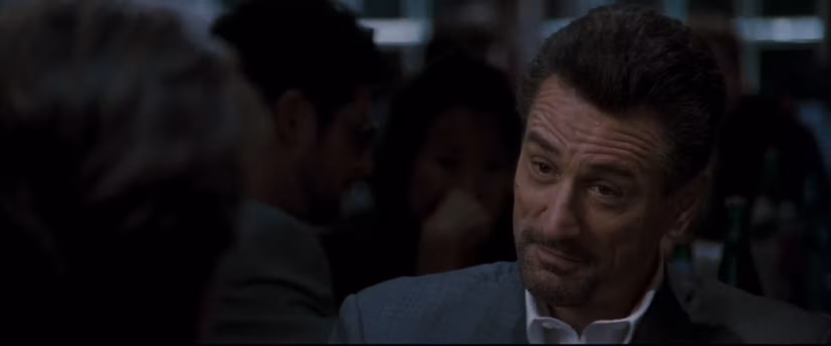 Em uma cena do filme Heat, a câmera foca em Robert De Niro, suprimindo um sorriso enquanto ele se senta à mesa de jantar de Al Pacino (não na foto). Eles estão interpretando um criminoso e um policial sentados tomando uma xícara de café tranquilamente.