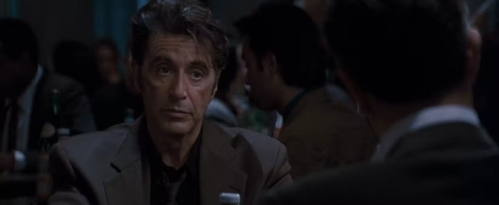 Em cena do filme Heat, a câmera foca no rosto de Al Pacino enquanto ele discute a vida em frente à mesa de Robert De Niro. Eles estão brincando de policial e criminoso, sentando-se para tomar uma xícara de café.