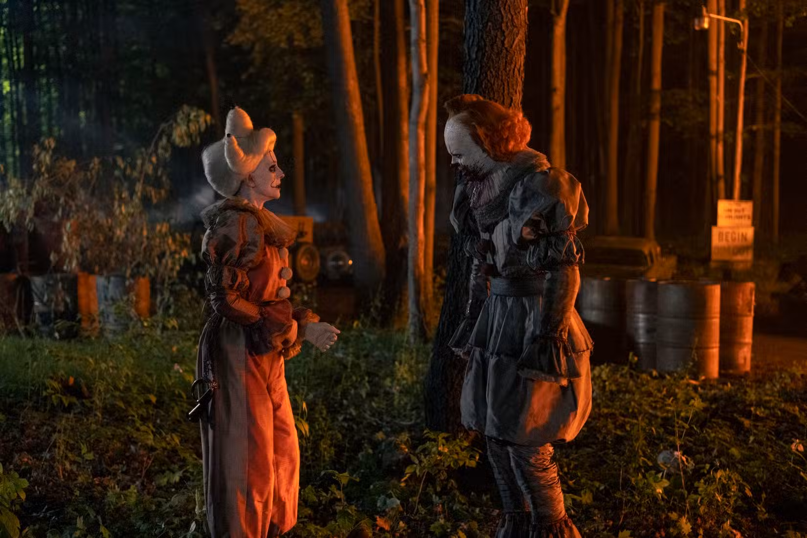 Ingrid (Madeleine Stowe) em sua fantasia de palhaço, aproximando-se de Pennywise (Bill Skarsgard), pensando que ele é o pai dela em Welcome to Derry