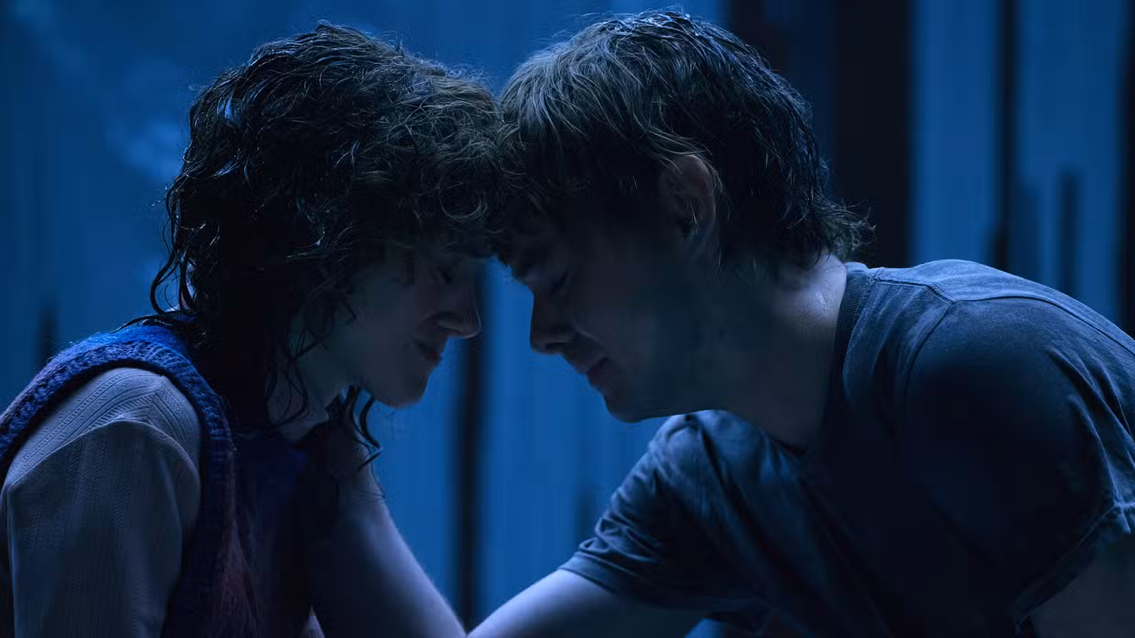 Nancy Wheeler (Natalia Dyer) chora sentada com a cabeça pressionada contra Jonathan Byers (Charlie Heaton) na 5ª temporada de Stranger Things 