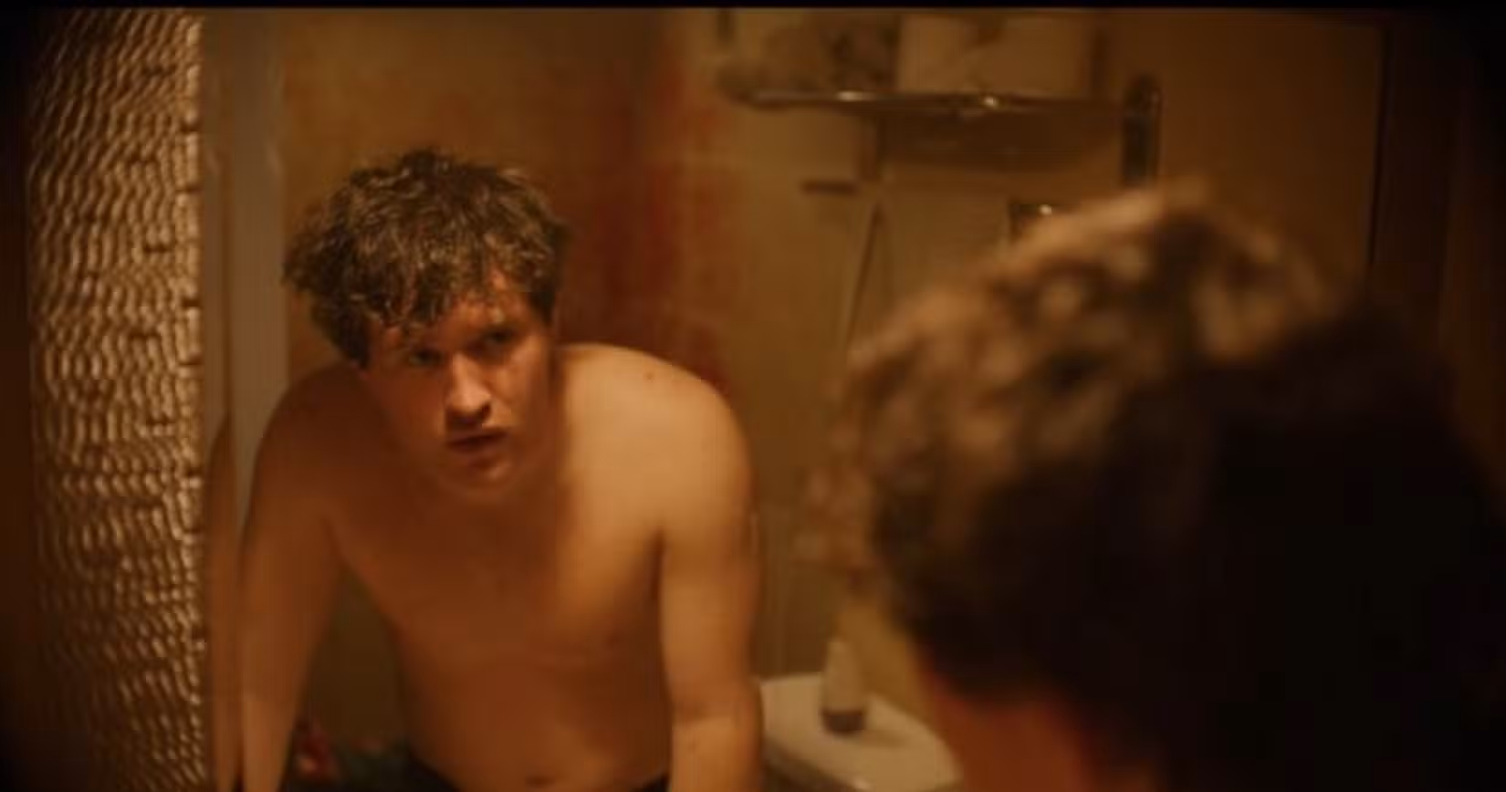 Billy (Rohan Campbell) o encara no espelho, sem camisa, refletindo sobre os possíveis delitos que cometeu enquanto se vestia de Papai Noel na versão 2025 de Silent Night, Deadly Night