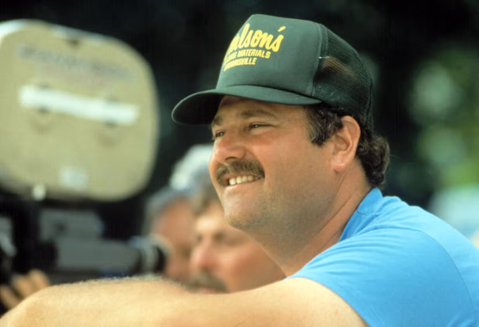 Rob Reiner com boné de caminhoneiro dirigindo Stand by Me em 1985.