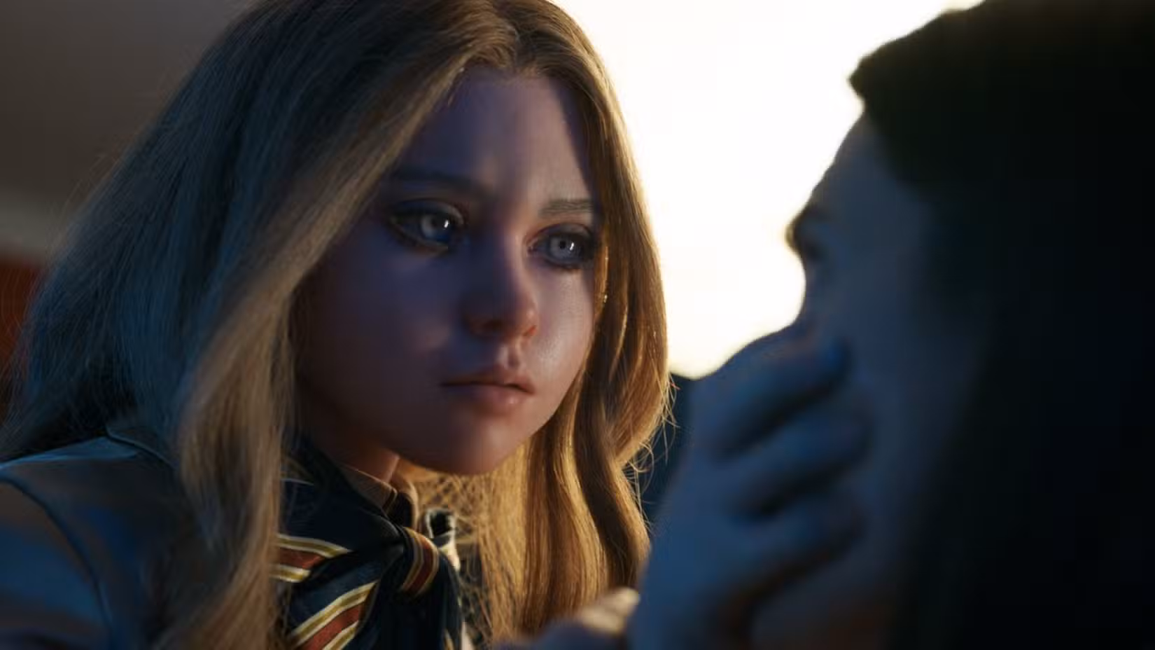 A boneca IA assassina M3GAN (Amie Donald) agarra sua criadora Gemma (Allison Williams) pelo rosto em M3GAN