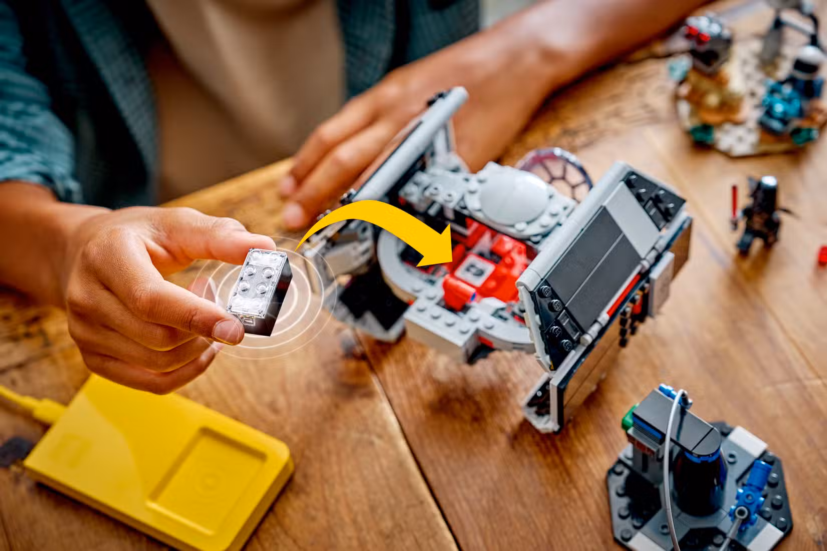 Uma criança insere um Lego Smart Brick em um conjunto Lego Darth Vader TIE Fighter