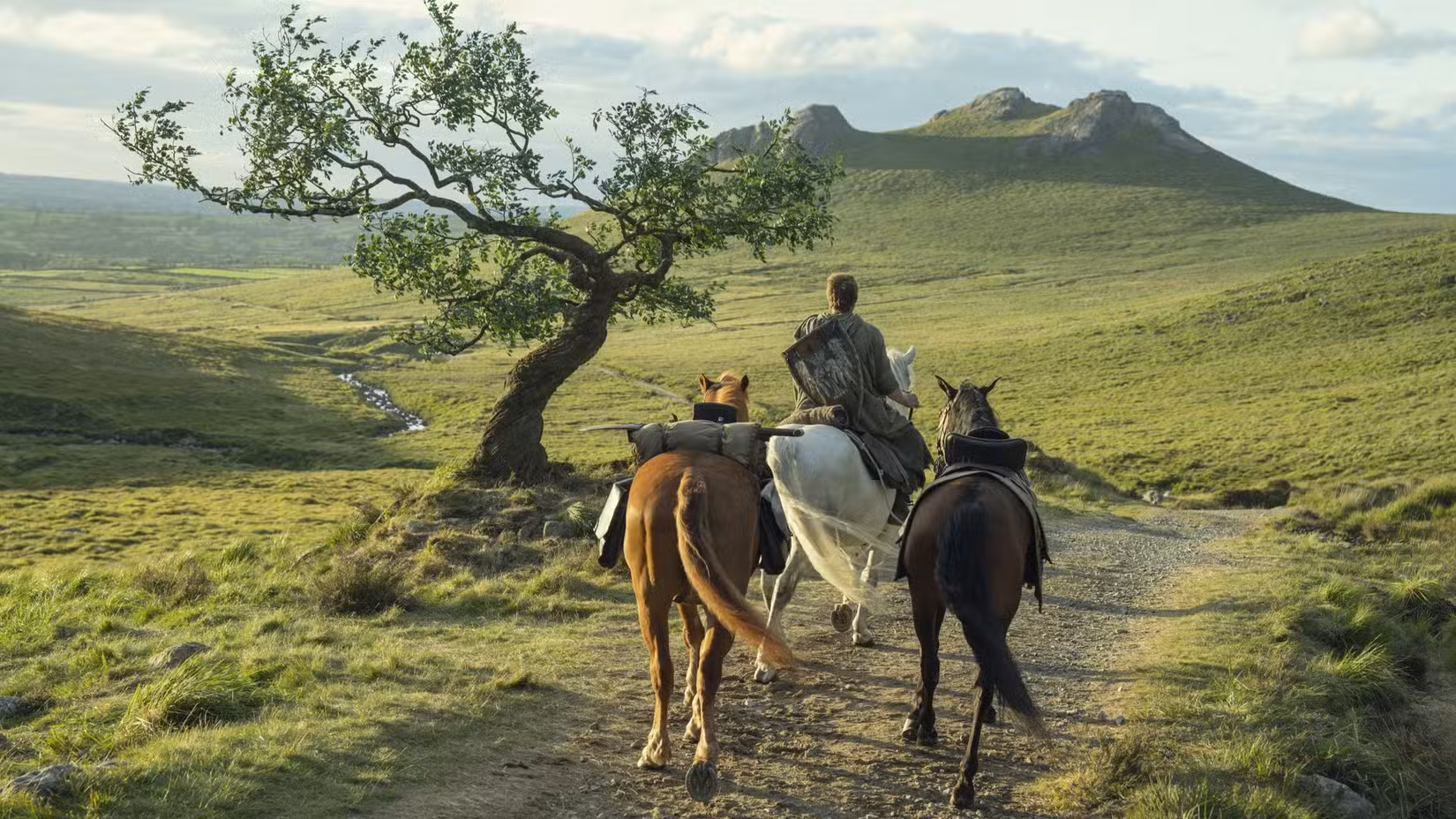 Peter Claffey como Dunk cavalgando com dois cavalos atrás em um passeio gramado em Um Cavaleiro dos Sete Reinos