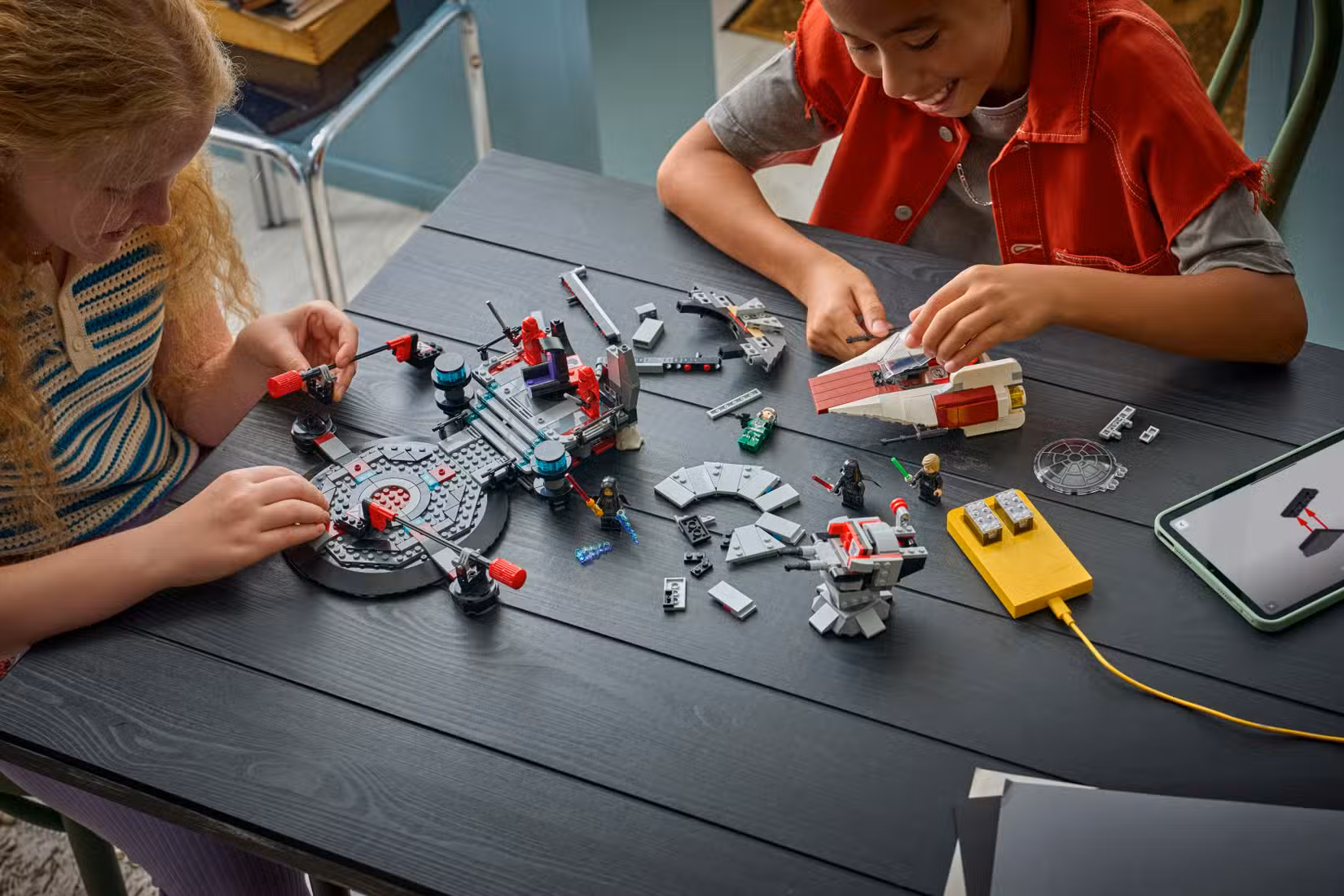 Duas crianças trabalhando juntas para construir o conjunto Lego Smart Play Star Wars Throne Room