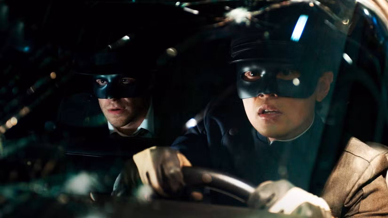 Kato (Jay Chou) assume o volante de um carro modificado, com o Green Hornet (Seth Rogen) andando de espingarda nesta imagem noturna de The Green Hornet de 2011.