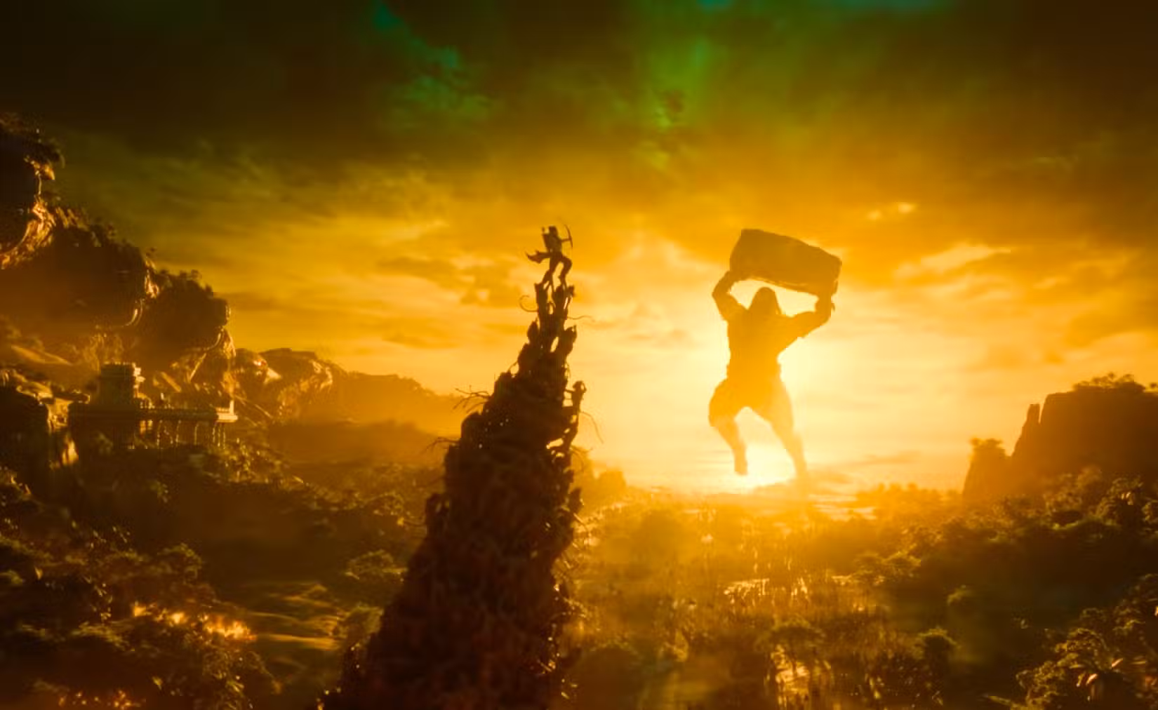 uma captura de tela do trailer de Varanasi mostrando uma pirâmide humana gigante com a pessoa no topo atirando arco e flecha contra um enorme deus mitológico