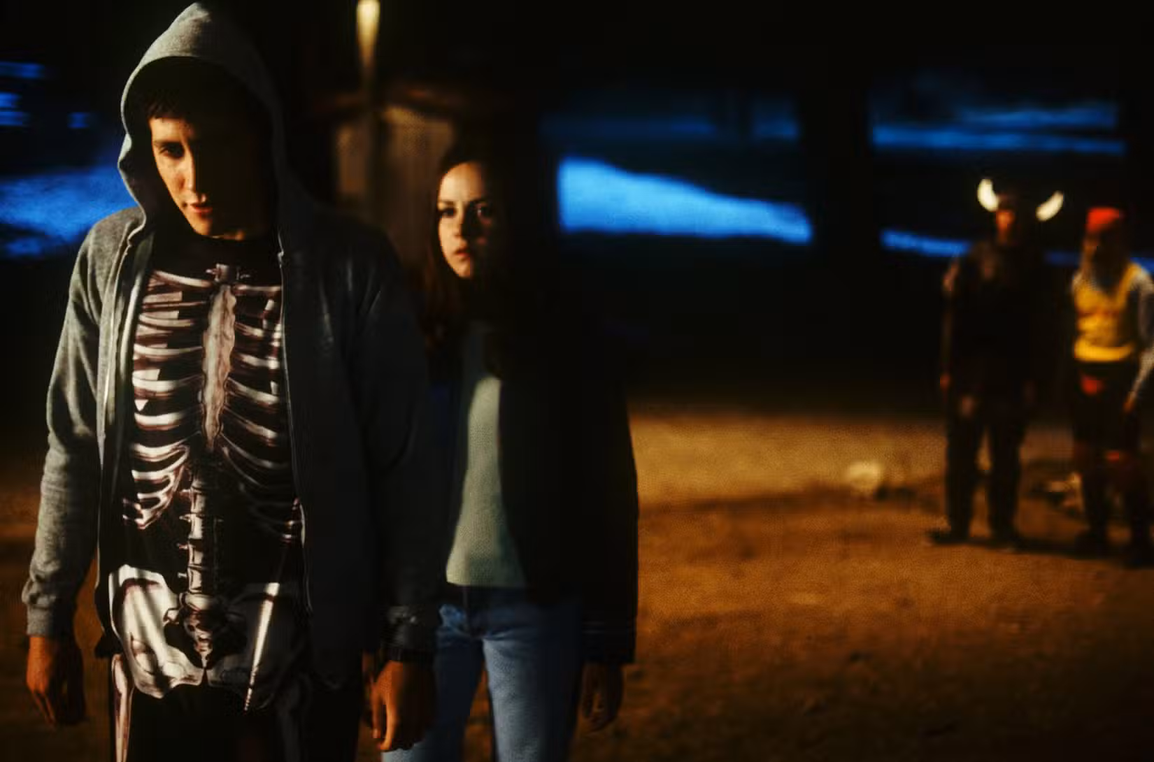 Jake Gyllenhaal, vestindo um moletom com capuz sobre um macacão de esqueleto, e Jena Malone em Donnie Darko