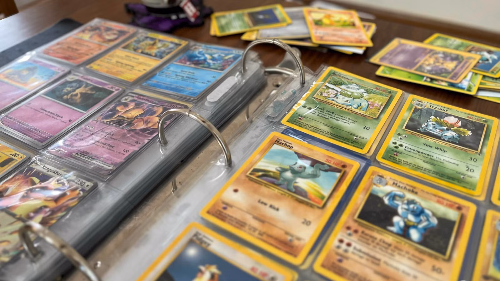Uma foto de duas páginas de um fichário aberto com cartas de Pokémon. Ele mostra cartas do conjunto Scarlet & Violet-151 ao lado de outras cartas mais antigas.